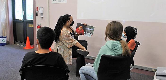 在马萨诸塞州汉斯科姆空军基地，一名BSU学生给小学生读书